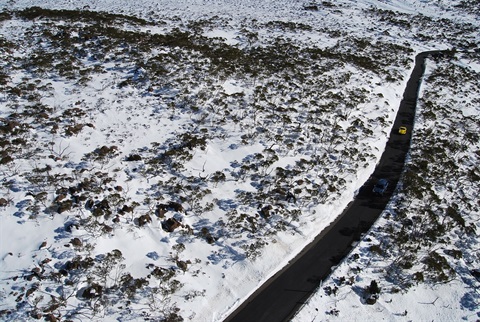 Picture of cars driving up mountain in the snow 