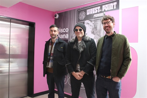 Three males who created the 6 storeys 6 stories creative installation stand in front of level 5 at Argyle Street car park.